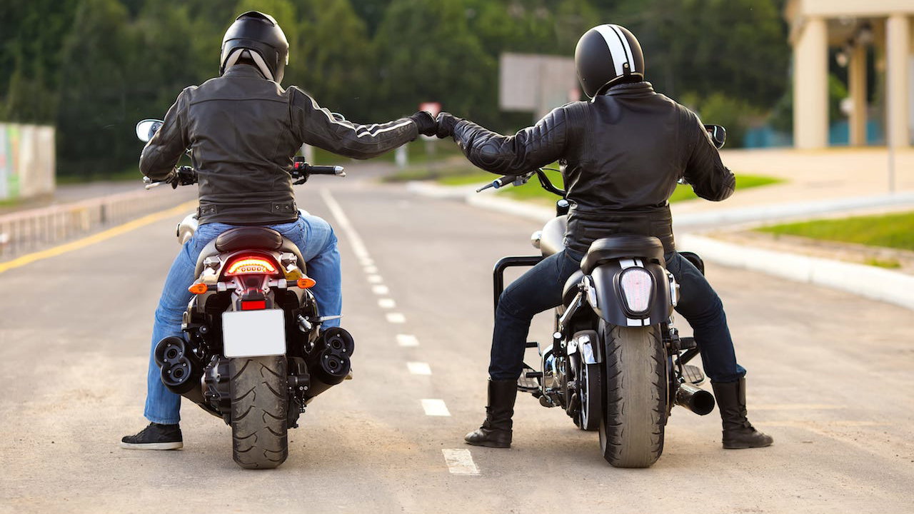 motorcyclist stood next to motorcycle with motorbike helmet
